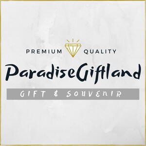 Może przedstawiać: Logo sklepu z pamiątkami o nazwie "Paradise Giftland" z napisami "Premium Quality" i "Gift & Souvenir" pod logo. Logo przedstawia diament z złotą obw&oacute;dką i złotą gwiazdą nad nim.