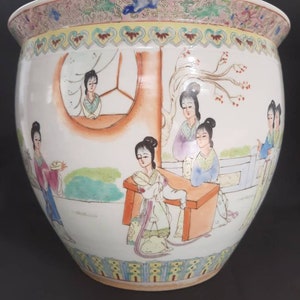 Könnte beinhalten: Ein großer weißer Porzellantopf mit einem bunten Blumendesign am Rand und einer Szene mit Frauen in traditioneller chinesischer Kleidung, die auf die Seite gemalt ist.