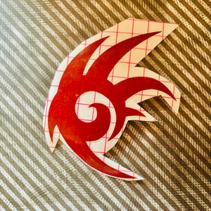 Könnte beinhalten: Roter Vinyl-Aufkleber mit dem Sonic the Hedgehog-Logo. Das Logo ist ein stilisierter roter Wirbel mit drei Punkten.