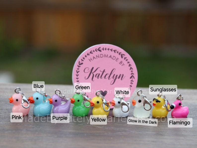 May include: Ten colorful rubber duck charms with silver jump rings. The ducks are pink, blue, purple, green, yellow, white, glow in the dark, sunglasses, and flamingo.