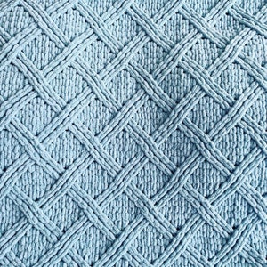May include: A light blue knitted throw blanket with a diamond pattern.