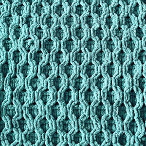 Puede incluir: Tejido de punto azul turquesa con un patrón texturizado y tejido.