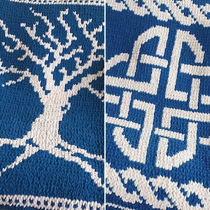 Op de afbeelding: Een gebreide deken met een wit boomontwerp op een blauwe achtergrond. De andere kant van de deken heeft een wit Keltisch knoopontwerp op een blauwe achtergrond.