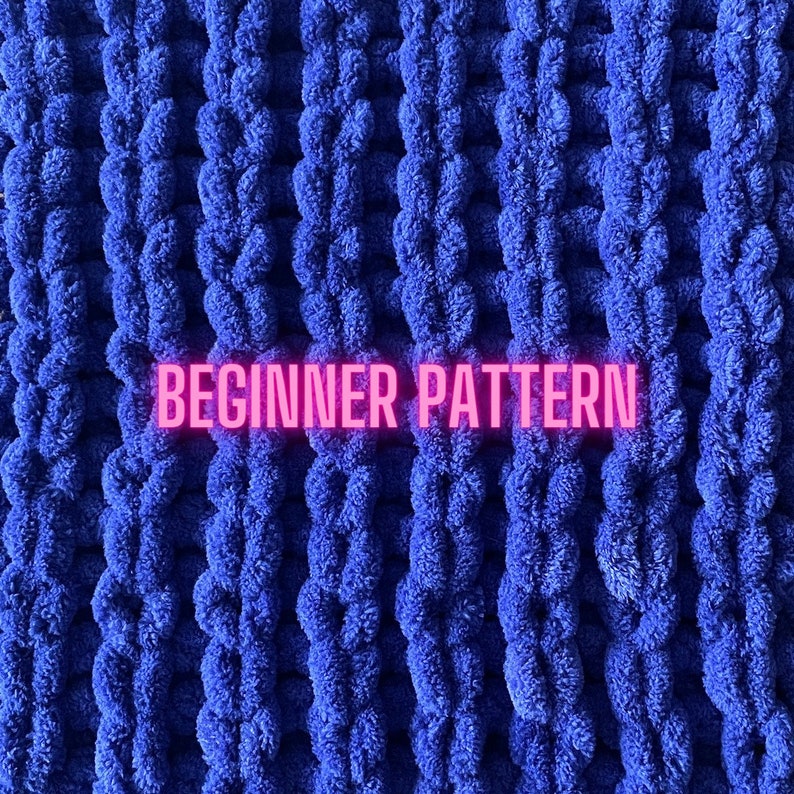 May include: A close-up of a blue knitted blanket with a textured, puffy surface. The text "BEGINNER PATTERN" is written in pink across the middle of the blanket.