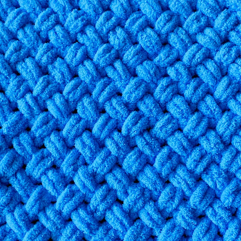 May include: A close-up of a blue knitted fabric with a textured, woven pattern.