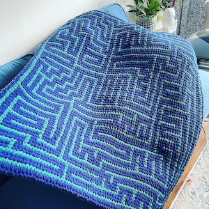 May include: A blue and green crocheted throw blanket with a maze pattern.