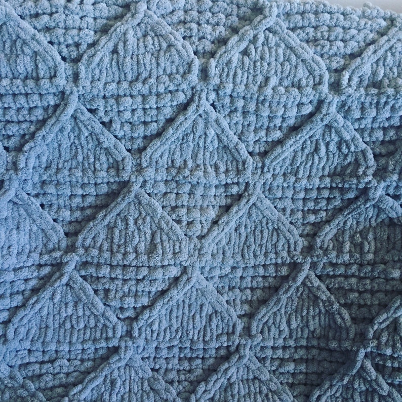 May include: A soft, blue, crocheted throw blanket with a diamond pattern.