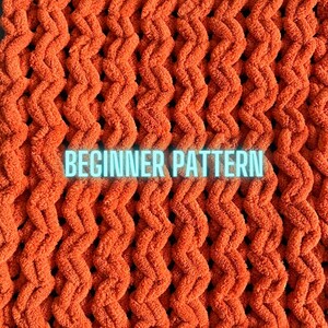 May include: Close-up of a woven orange fabric with a textured, wavy pattern. The fabric has a "BEGINNER PATTERN" label.