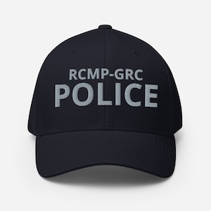 May include: A navy blue baseball cap with the text "RCMP-GRC POLICE" embroidered in white on the front.