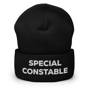 Puede incluir: Gorro negro con una inscripción bordada en blanco que dice "SPECIAL CONSTABLE".