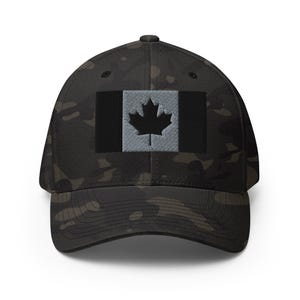May include: A black and grey camouflage baseball cap with a black and white Canadian flag patch on the front.