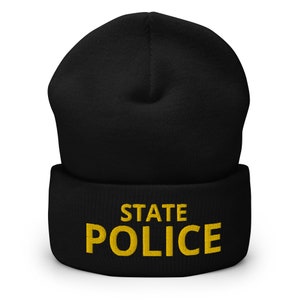 以下が含まれることがあります： 黄色の刺繍で「STATE POLICE」と書かれた、折り返しのついた黒いビーニー