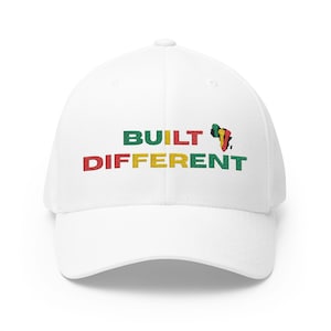 May include: White baseball cap with the words "BUILT DIFFERENT" embroidered in green, red, and yellow. A colorful graphic of the African continent is on the right side of the cap.