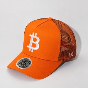 May include: A bright orange trucker hat featuring a white embroidered Bitcoin symbol on the front panel. The cap includes a mesh back, a curved brim with a circular sticker, and the Roman numeral IX embroidered in white on the side panel.