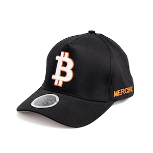May include: Black baseball cap with a white Bitcoin symbol and orange outline. The text "MERCH" is embroidered in orange on the side of the cap.