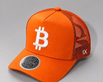 May include: A bright orange trucker hat featuring a white embroidered Bitcoin symbol on the front panel. The side panels are made of orange mesh. A circular sticker with the text IX MERCH is applied to the brim, and IX is embroidered on the side.