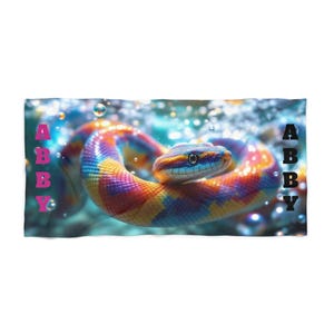 May include: A vibrant snake with a rainbow pattern is the central element of this image. The snake is coiled and surrounded by bubbles. The name "ABBY" is written vertically in pink and black letters on both sides of the snake.