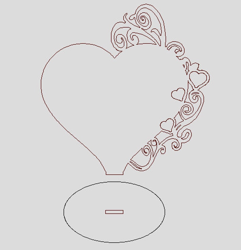 May include: A laser cut wooden heart-shaped frame with a decorative floral design and a small round base. The frame is perfect for displaying photos or other small items.