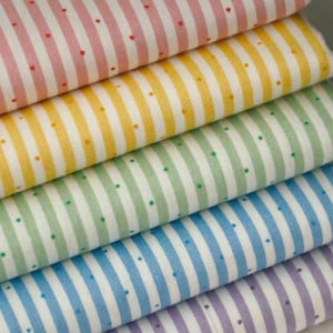 K&ouml;nnte beinhalten: Ein Stapel bunter Stoffmuster. Jeder Stoff hat vertikale Streifen in verschiedenen Farben: Rosa, Gelb, Gr&uuml;n, Blau und Lila. Kleine Punkte in einer Kontrastfarbe sind &uuml;ber die Streifen verteilt.