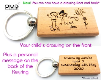 May include: A wooden keychain with a drawing of two stick figures and a sun on the front. The back of the keychain has a personalized message that says "Drawn by Jessica aged 5 Wednesday 6th May 2020".
