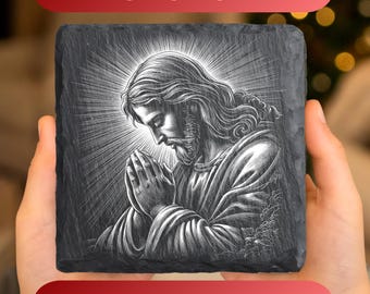 Könnte beinhalten: Ein quadratischer Schieferuntersetzer mit einer lasergravierten Abbildung von Jesus im Gebet. Das Bild ist detailliert mit einem Heiligenschein und fließendem Haar. Der Text "1 PNG FOR SLATE" und "LASER ENGRAVING DESIGN" sind abgebildet.