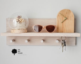 May include: A light wood shelf with five hooks, a glass dome with dried flowers, a pair of sunglasses, and a wooden clock with a gold hand. The shelf has the text "oh. my wood." printed below it.
