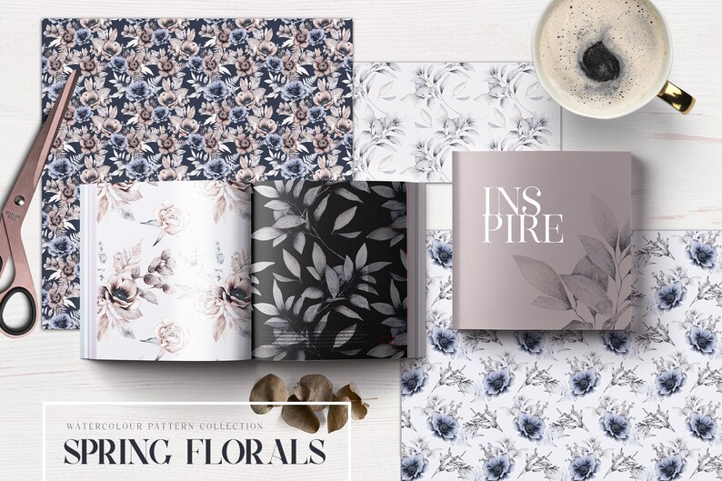 May include: A collection of watercolor floral patterns in shades of blue and pink. The patterns are arranged in a book with the word "INSPIRE" on the cover. The book is on a white surface with a cup of coffee and other floral patterns.