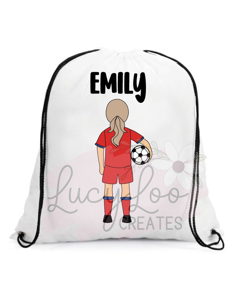 May include: White drawstring bag with black drawstrings. The bag has a black and white illustration of a girl in a red soccer jersey holding a soccer ball. The text "EMILY" is printed in black at the top of the bag.
