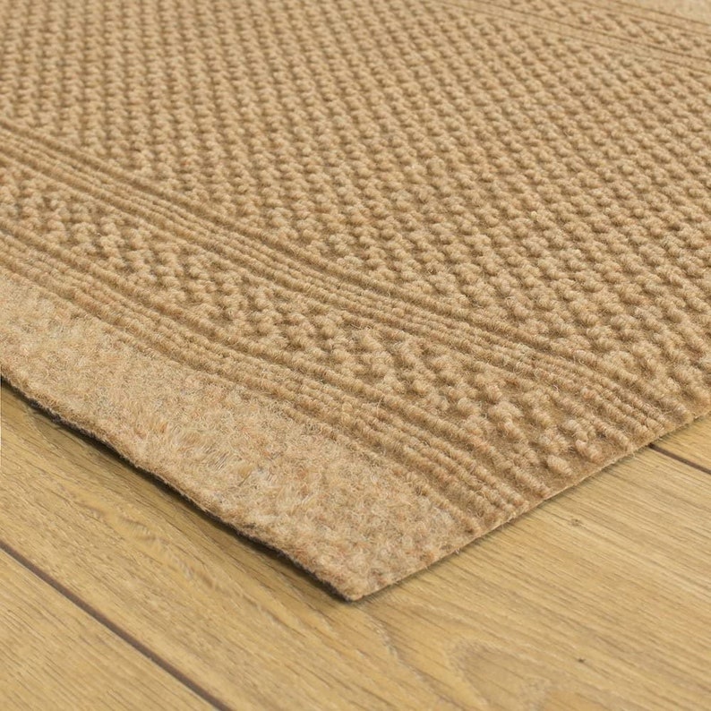 May include: A brown coir doormat with a textured pattern and a rubber backing. The mat is designed to help trap dirt and moisture from shoes.