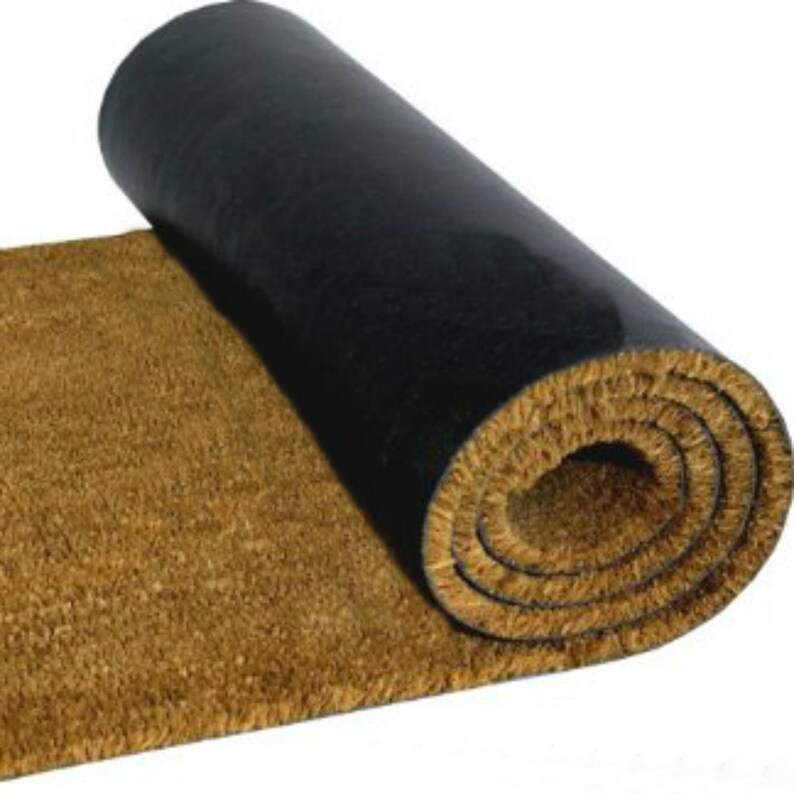 May include: A rolled-up brown coir doormat with a black rubber backing. The mat is made of natural fibers and is designed to trap dirt and moisture.