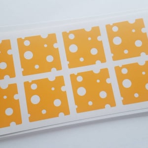 May include: A sheet of yellow and white stickers with a swiss cheese design. Each sticker has a different pattern of holes.