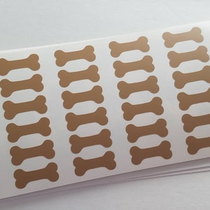 May include: Sheet of brown dog bone stickers on a white background.