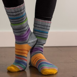May include: A pair of colourful striped socks with a grey base colour. The socks have a yellow toe and heel.