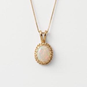May include: A gold necklace featuring an oval-shaped opal pendant. The opal is set within a twisted gold rope-style border and hangs from a delicate gold box chain. The stone displays iridescent flashes of color against a white base.