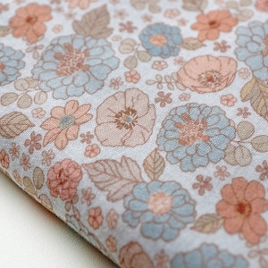 May include: A light blue fabric with a floral pattern in shades of pink and brown. The fabric features a variety of flowers, including roses, daisies, and poppies.