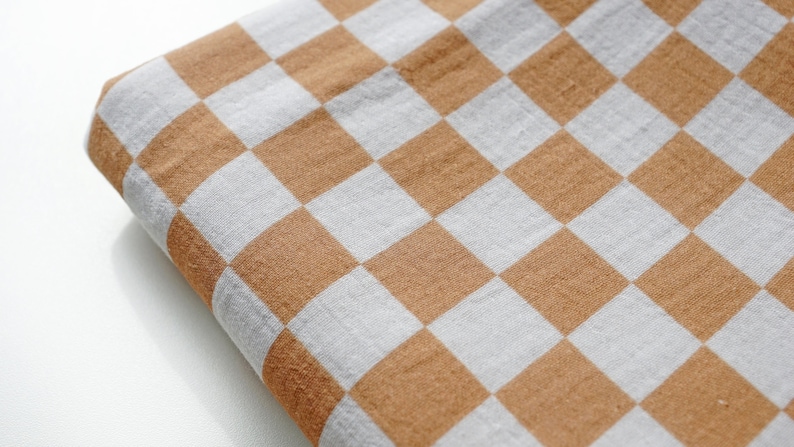 May include: A brown and white checkered fabric with a soft, textured surface.