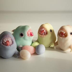 Giant microbe monsters with their eggs, funny polymer clay figurines in anime cartoon style