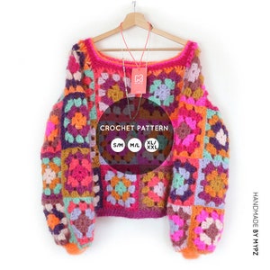 Op de afbeelding: Een kleurrijke gehaakte trui met een vierkant patroon in tinten roze, paars, groen, oranje en bruin. De trui heeft een losse pasvorm en lange mouwen. De tekst "CROCHET PATTERN" is op de trui gedrukt, samen met de maatopties: S/M, M/L, XL/XXL.