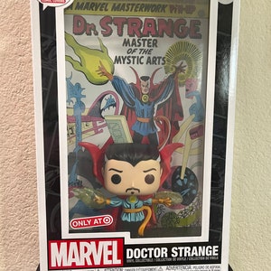 May include: A Funko Pop! Comic Covers collectible figure of Doctor Strange, the Master of the Mystic Arts, in a clear plastic display case with a vintage comic book cover featuring Doctor Strange. The case has a black and white border and a white background with the number 04 in the top right corner. The comic book cover features a yellow and orange flame effect and the text "Marvel Masterwork Pin-Up Dr. Strange Master of the Mystic Arts". The figure is wearing a red cape and a blue and yellow costume. The figure is holding a green and yellow energy ball in each hand. The case has a white label on the bottom with the text "Marvel Doctor Strange Vinyl Collectible/Collection de Vinyle/Colecci&oacute;n de Vinilo" and a warning label with the text "WARNING: CHOKING HAZARD ATTENTION: DANGER D'ETOUFFEMENT ADVERTENCIA: PELIGRO DE ASFIXIA".
