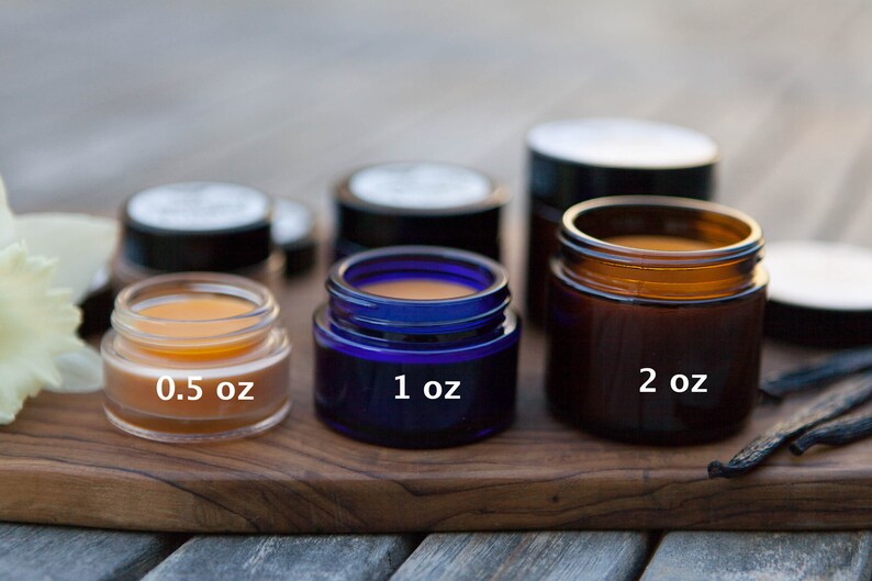 K&ouml;nnte beinhalten: Drei Glasbeh&auml;lter in verschiedenen Gr&ouml;&szlig;en und Farben, die eine gelbe Substanz enthalten. Die Beh&auml;lter sind mit 0,5 oz, 1 oz und 2 oz beschriftet. Die Beh&auml;lter stehen auf einer Holzoberfl&auml;che.