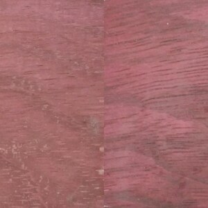 May include: Close-up of a piece of Purple Heart wood, displaying a rich, reddish-purple hue with visible wood grain patterns. The text "Purple Heart" is visible in the lower left corner.