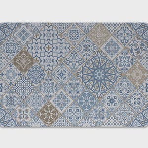 Könnte beinhalten: Eine rechteckige Matte mit einem sich wiederholenden Muster aus quadratischen Fliesen in Rautenanordnung. Das Design besteht aus verschiedenen komplexen geometrischen und floralen Motiven in Blau-, Hellgrau- und gedeckten Brauntönen auf weißem Grund.