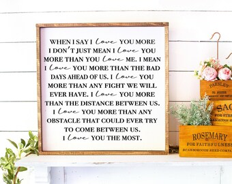 May include: A wooden framed sign with the text "When I say I love you more... I love you the most." Decorative wooden boxes labeled "Parsley", "Sage", and "Rosemary" are displayed on a white shelf.