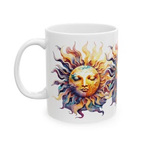 May include: White ceramic mug with a colorful sun design. The sun has a face with closed eyes and is surrounded by yellow, orange, purple, and blue rays.