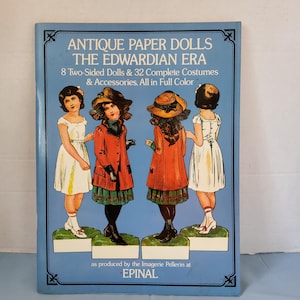May include: A book cover featuring four paper dolls dressed in Edwardian era clothing. The book title is "Antique Paper Dolls The Edwardian Era" and the text below states "8 Two-Sided Dolls & 32 Complete Costumes & Accessories, All in Full Color as produced by the Imagerie Pellerin at EPINAL."