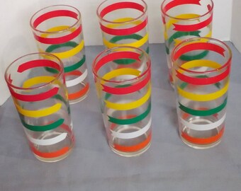 May include: Set of six clear glass drinking glasses with red, yellow, green, and white striped designs. Each glass has a different pattern of stripes.