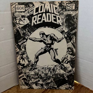 May include: A black and white comic book cover featuring The Phantom, a masked superhero, with the title "Comic Reader" and the date "August 1976".