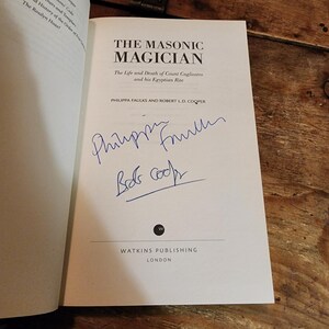 Puede incluir: Un libro blanco con el t&iacute;tulo "The Masonic Magician: The Life and Death of Count Cagliostro and his Egyptian Rite" de Philippa Faulks y Robert L.D. Cooper. El libro est&aacute; firmado por los autores.