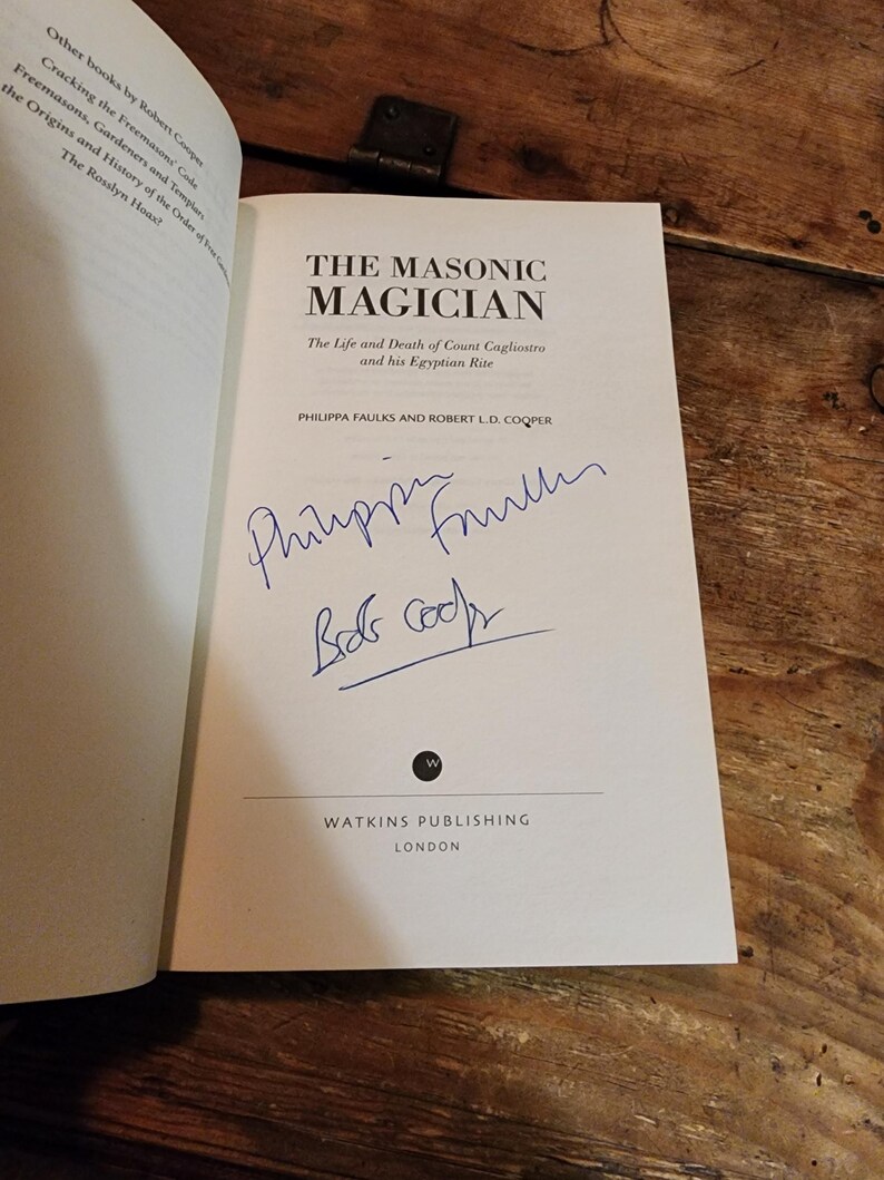 Puede incluir: Un libro blanco con el t&iacute;tulo "The Masonic Magician: The Life and Death of Count Cagliostro and his Egyptian Rite" de Philippa Faulks y Robert L.D. Cooper. El libro est&aacute; firmado por los autores.