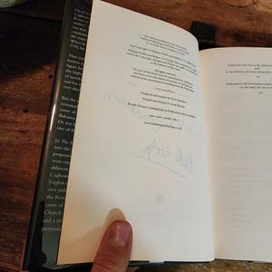 Puede incluir: Un libro blanco con texto negro en la portada. El libro est&aacute; abierto en una p&aacute;gina con una dedicatoria e informaci&oacute;n de copyright. El texto en la p&aacute;gina dice: "Dedicado con amor a la Orden Mas&oacute;nica, a la memoria del Conde Alessandro..." y "Dedicado a todos los masones que fueron... en la tierra, el mar o... BC."